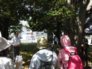 平和公園で、仏石塚の説明をしている様子を撮影した写真