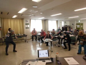 スクワットのような運動をみんなでやっているところ