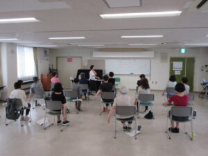 首元に手をあて、腕をのばしている