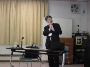 講師がプロジェクターに映っている内容を説明しているところ