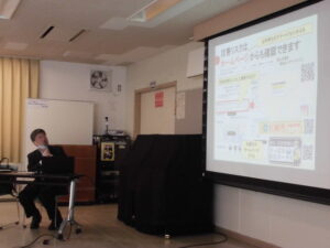 講師がプロジェクターに映っている内容を説明しているところ