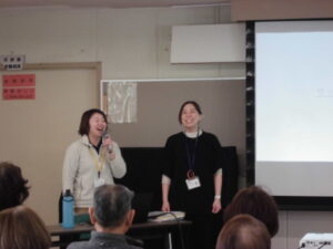 講師２名が学園生みんなに笑顔で話しているところ